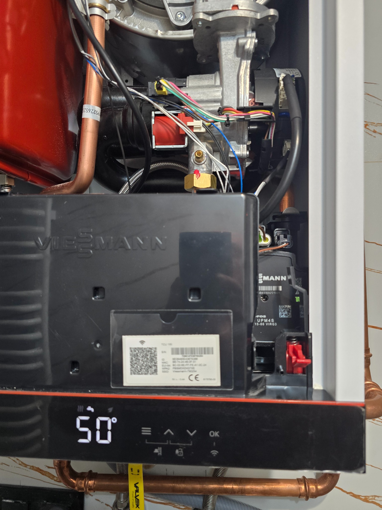 Wnętrze nowoczesnego pieca gazowego Viessmann z widocznymi elementami instalacji, przewodami i wyświetlaczem wskazującym temperaturę 50 stopni Celsjusza.