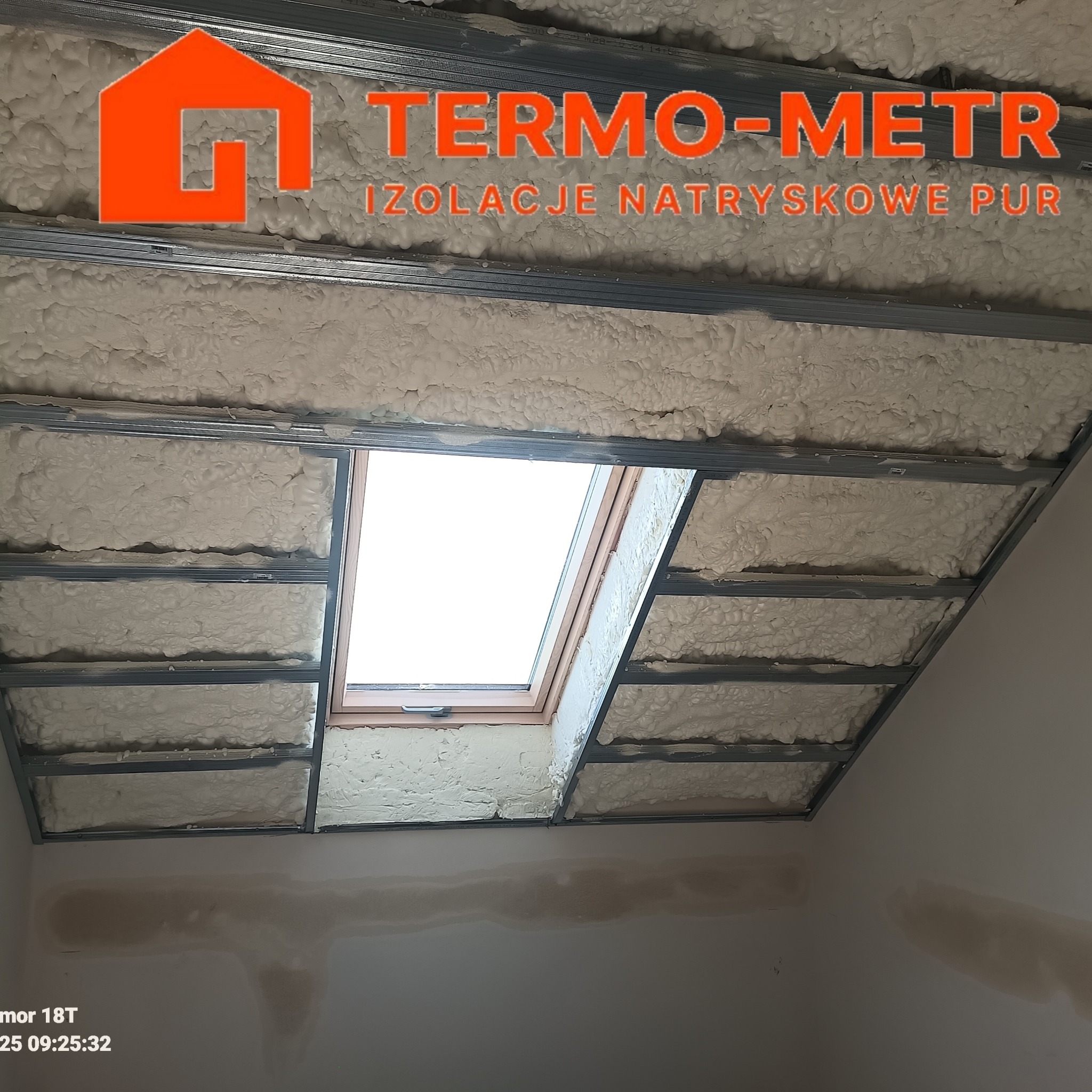 Poddasze ocieplone pianką PUR w metalowej konstrukcji, widoczny fragment okna dachowego. Izolacja natryskowa wykonana przez TERMO-METR.