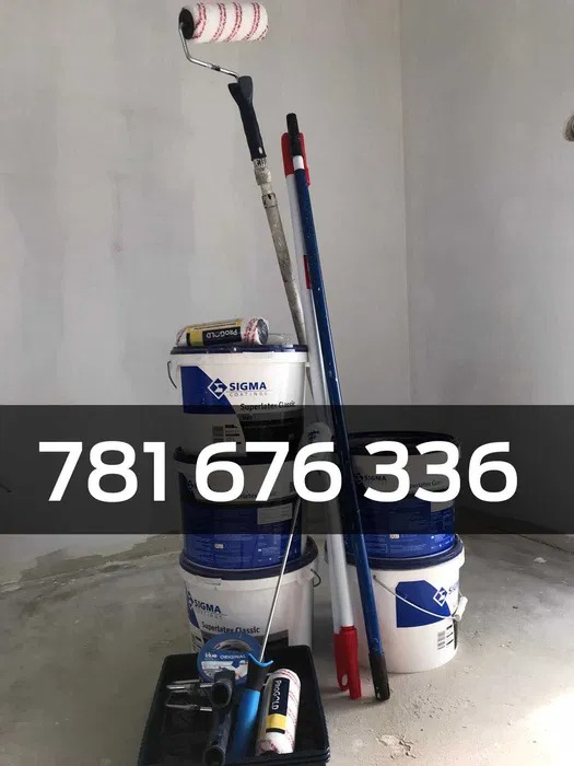 Stos wiader z farbą Sigma, wałki malarskie z teleskopowymi uchwytami oraz kuweta na farbę w narożniku pomalowanego na szaro pokoju.