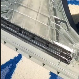 Ivan Sosiedko - Dysza odkurzacza piorącego na wzorzystym dywanie z bliska, widoczne detale konstrukcyjne i oznaczenia na plastiku.