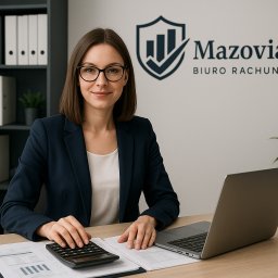 Mazovia HR Barbara Ronczkowska - Kobieta w okularach i marynarce siedzi przy biurku z kalkulatorem i laptopem, za nią logo MazoviaHR. Profesjonalne biuro rachunkowe.