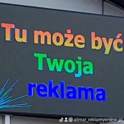 Podświetlany billboard z napisem 'Tu może być Twoja reklama' w kolorach tęczy, widoczny adres TikTok firmy w rogu.