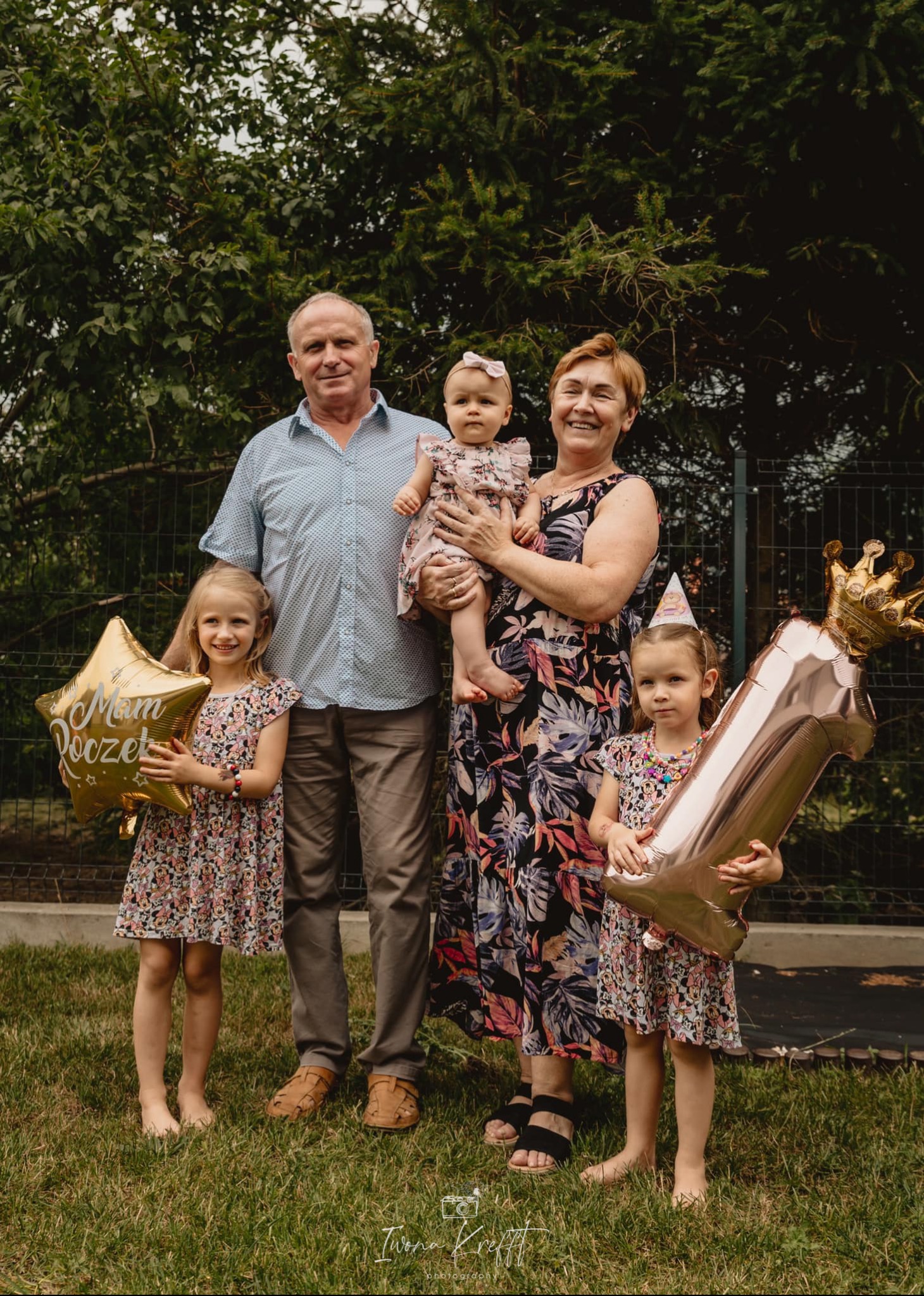 Rodzinne zdjęcie z okazji pierwszych urodzin dziecka, z balonami w kształcie gwiazdy i cyfry jeden