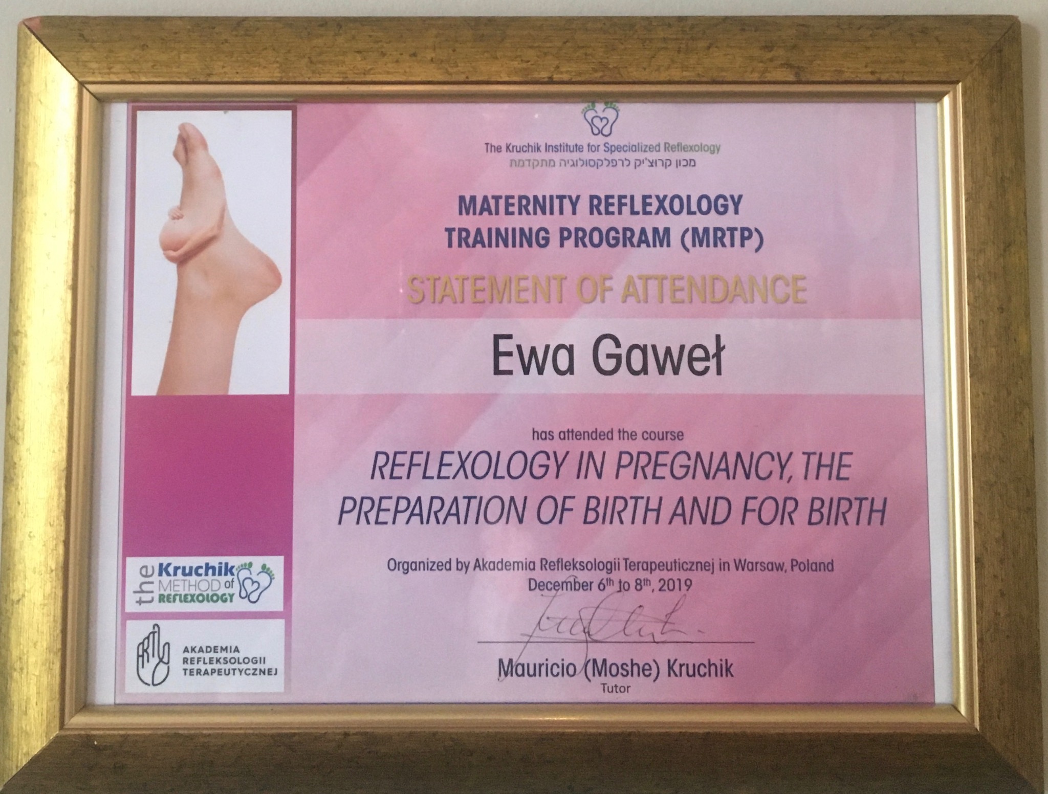 Oprawiony certyfikat ukończenia kursu refleksologii ciążowej Ewy Gaweł, z logo The Kruchik Institute for Specialized Reflexology i ilustracją stopy, podpisany przez Mauricio (Moshe) Kruchika.