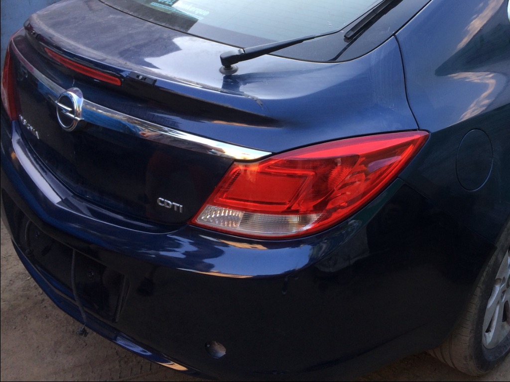 Tył granatowego samochodu Opel Insignia z widocznym światłem, chromowaną listwą, emblematem i oznaczeniem CDTI.