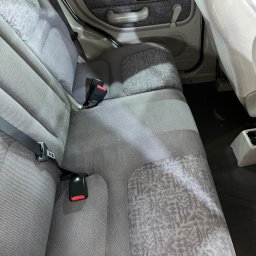 Maciej Wyżga - Szare tylne siedzenia samochodu z wzorzystymi wstawkami i czarnymi pasami bezpieczeństwa.