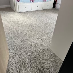 Maciej Wyżga - Jasnoszary dywan z krótkim włosiem po profesjonalnym praniu, widoczne ślady odkurzacza, dziecięcy pokój z białymi meblami w tle.