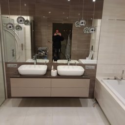 Sławomir filipiak - Nowoczesna łazienka z dwoma umywalkami nablatowymi, dużym lustrem i wiszącymi lampami kulami, widok odbicia fotografa w lustrze.