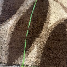 Paweł Wieczorek - Wielobarwny, puszysty dywan z ciemnymi i jasnymi pasami, z widoczną zieloną liną na jego powierzchni.