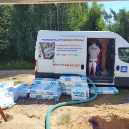 ADMAR Mariusz Pedda - Ocieplanie wdmuchiwaniem: biały bus firmy ADMAR z otwartymi drzwiami, pracownik w środku, na zewnątrz worki z wełną Supafil i wąż do wdmuchiwania, widoczne drzewa i dom w tle.