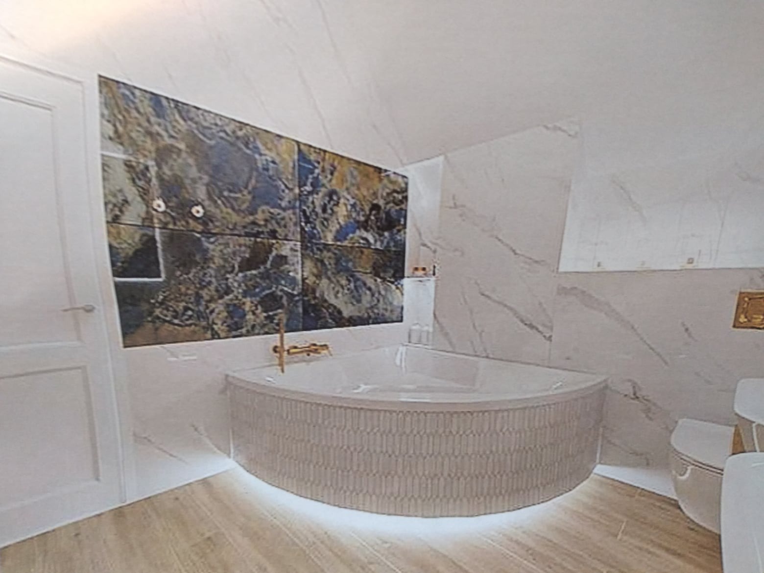 Nowoczesna łazienka z narożną wanną z podświetleniem LED, marmurowymi płytkami na ścianach i drewnianą podłogą.