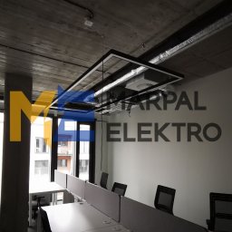 Marpal Elektro Sp. z o.o. - Nowoczesne biuro z zainstalowanym systemem oświetlenia liniowego pod sufitem, widoczne elementy instalacji elektrycznej i wentylacyjnej.