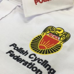 Everglow Paweł Świąć - Biała koszulka polo z wyhaftowanym napisem 'POLSKA' na kołnierzyku, herbem PZKOL i napisem 'Polish Cycling Federation'.