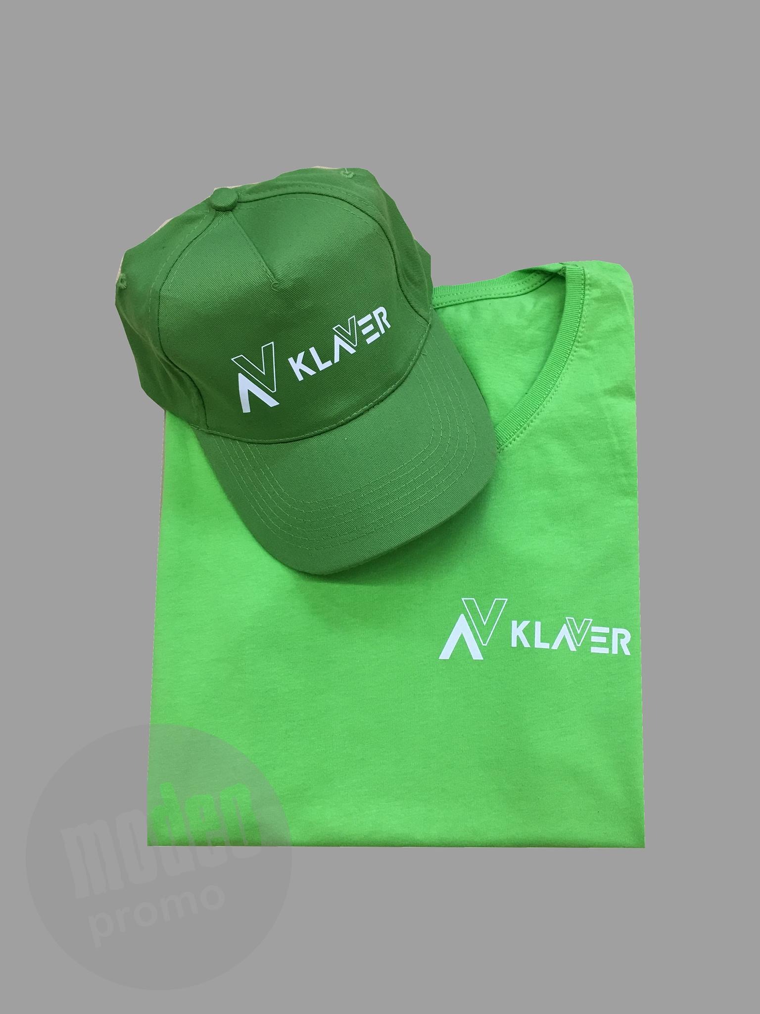 Zielona koszulka i czapka z białym nadrukiem logo firmy 'Klaver', leżące na szarym tle.