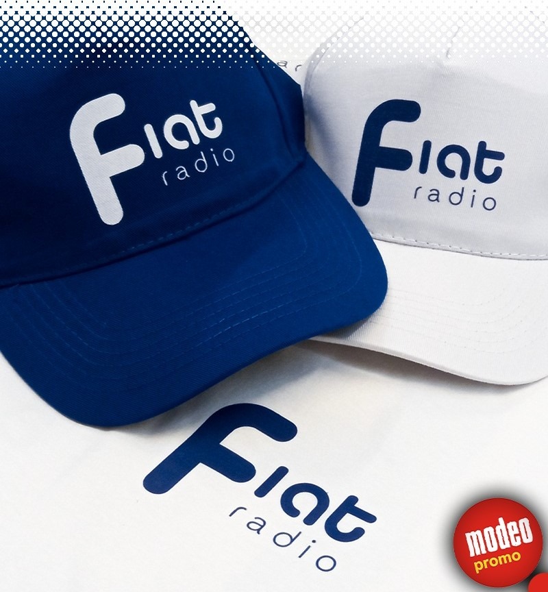 Dwie czapki z daszkiem, granatowa i biała, z nadrukowanym logo 'Fiat radio', leżące obok nadrukowanego logo na białym tle.