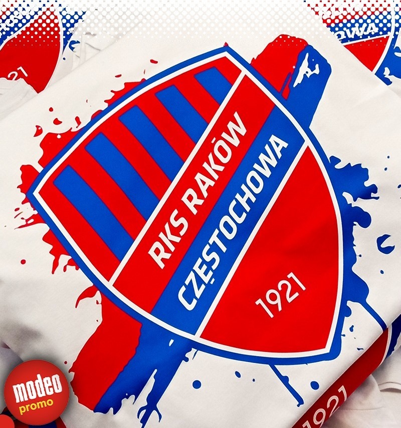 Biała koszulka z nadrukowanym herbem RKS Raków Częstochowa w kolorach czerwonym i niebieskim, stylizowanym na rozprysk farby.