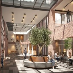 Studio MBG - Nowoczesne atrium biurowca z ceglanymi ścianami, szklanym dachem i dużym drzewem oliwnym w centrum. Ludzie pracują i odpoczywają na różnych poziomach, przy geometrycznej posadzce.