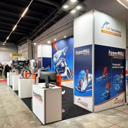 Agencja Promocyjno-Reklamowa SPOT s.c. Piotr Czerwiński, Wojciech Krawczyk - Stoisko targowe z grafiką HyperMill prezentujące rozwiązania CAD/CAM i obróbki skrawaniem, z komputerem na pierwszym planie i osobami w tle.