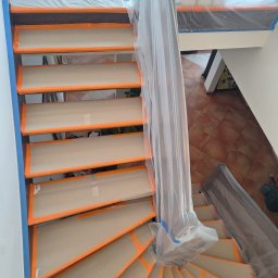 Ivan Katrych - Schody zabezpieczone folią i taśmą malarską przed malowaniem. Widok z góry na spiralne schody w trakcie przygotowań do prac malarskich.