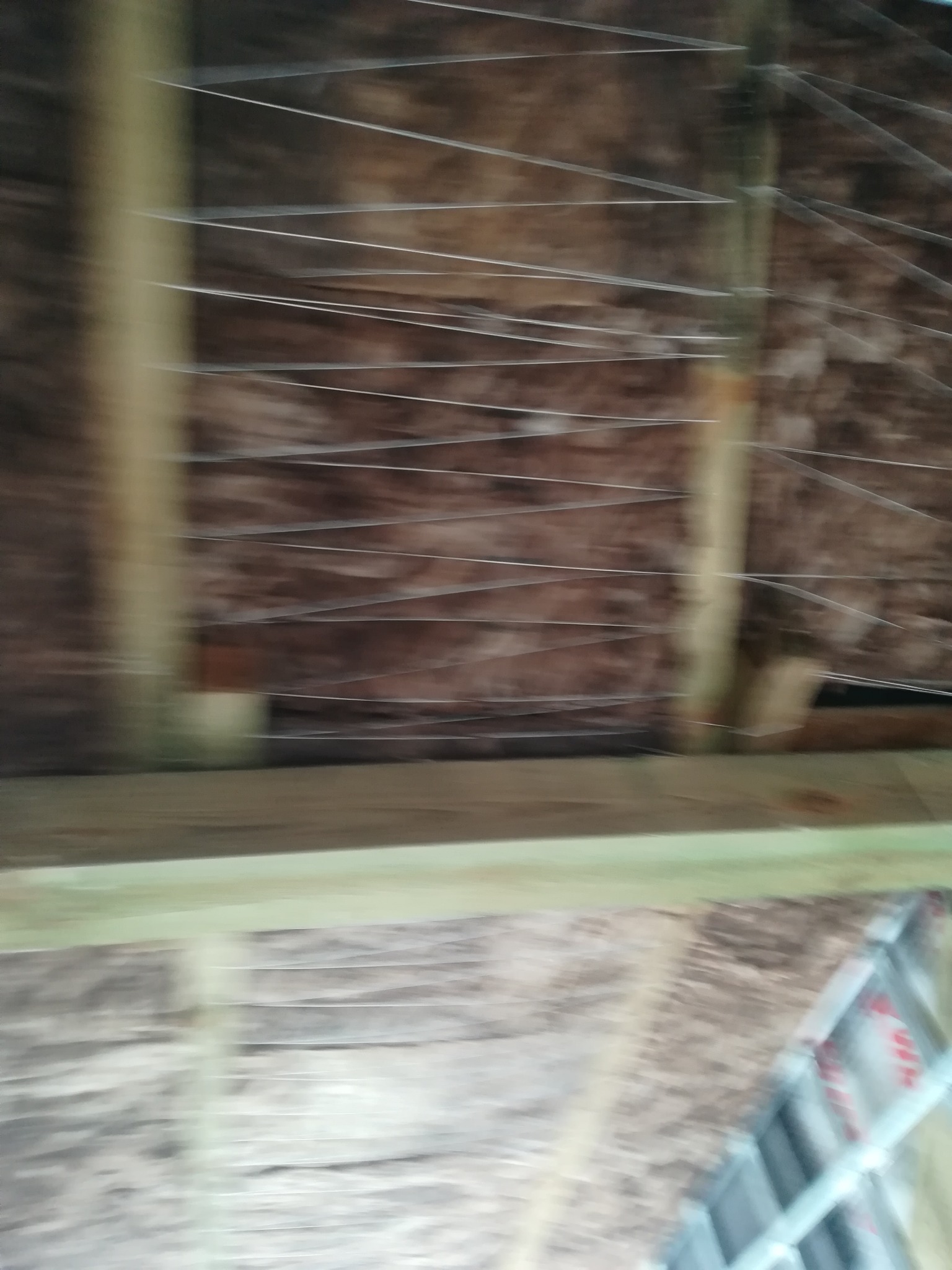 Montaż metalowych listew na drewnianej konstrukcji poddasza, prawdopodobnie przygotowanie pod izolację lub zabudowę.