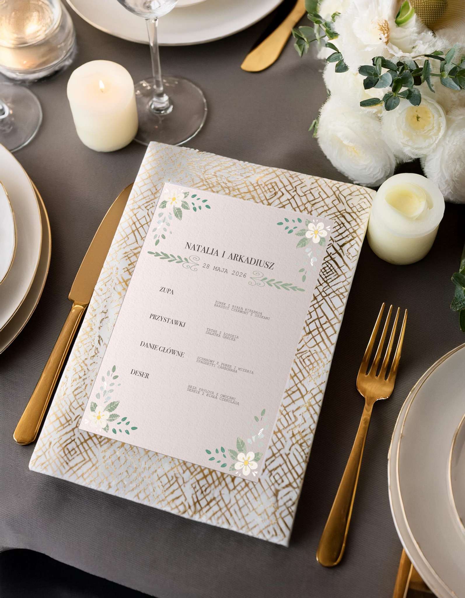 Elegancko zaaranżowany stół weselny z menu na kartce zdobionej kwiatowym motywem, umieszczonej na ozdobnej podkładce w złote wzory, w otoczeniu świec, białych kwiatów i zastawy stołowej...
