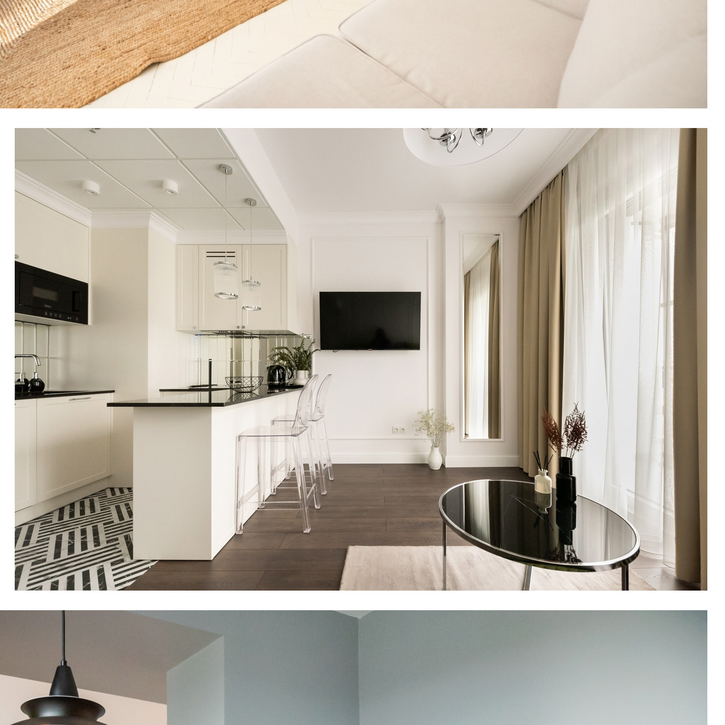 Jasne, nowoczesne wnętrze z aneksem kuchennym, czarnym blatem, transparentnymi krzesłami barowymi i okrągłym stolikiem kawowym z dekoracjami.