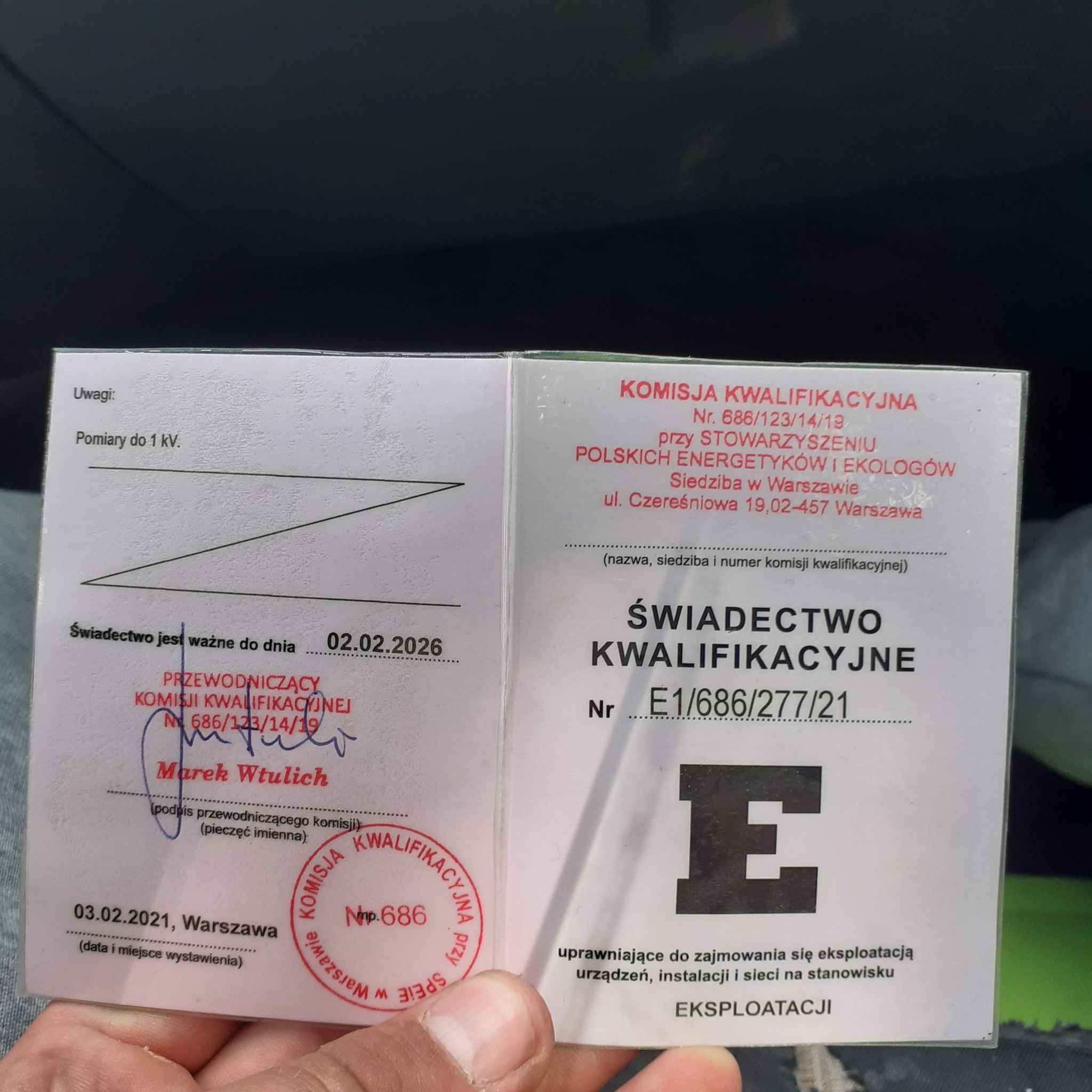 Otwarta książeczka Świadectwa Kwalifikacyjne nr E1/686/277/21, uprawniającego do eksploatacji urządzeń, instalacji i sieci, z pieczątką i podpisem Przewodniczącego Komisji Kwalifikacyjnej, ważna...