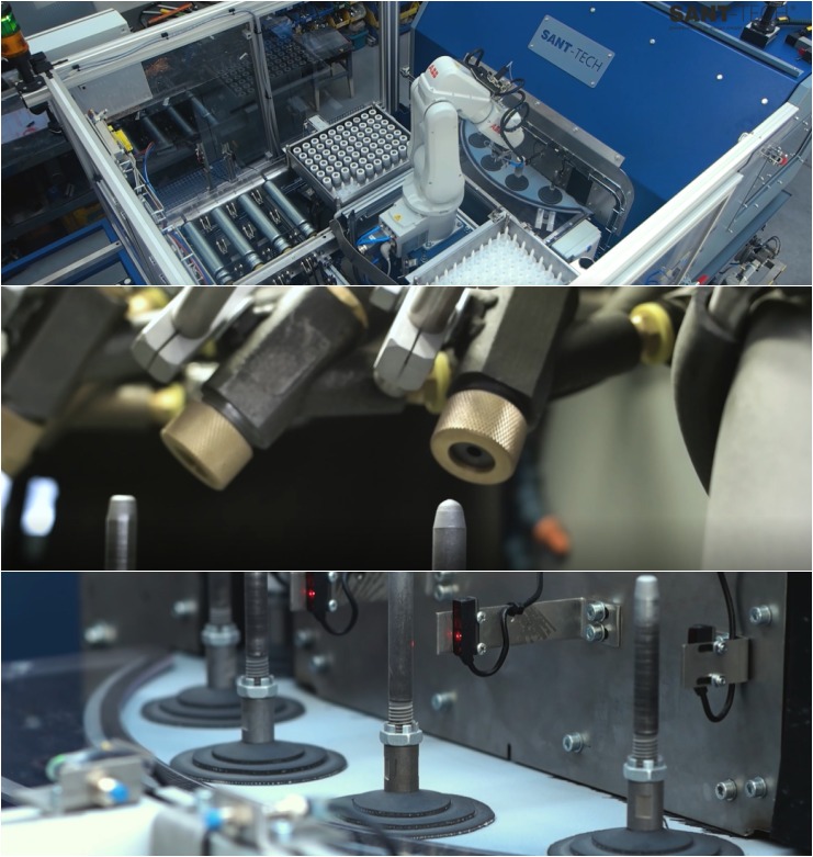 Zautomatyzowana linia produkcyjna z robotem przemysłowym, zbliżenie na dysze aplikujące substancję na obracające się elementy, widoczne czujniki i detale konstrukcyjne.