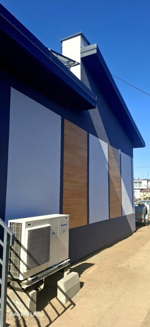 Elewacja budynku w Częstochowie z panelami imitującymi drewno, szarą farbą i zamontowaną klimatyzacją Panasonic na zewnątrz.