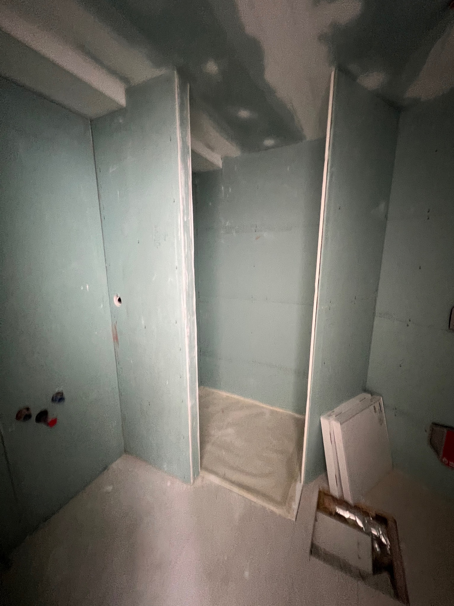 Wnętrze w trakcie prac wykończeniowych: montaż płyt kartonowo-gipsowych, widoczne profile i surowy beton na podłodze, przygotowanie do dalszych etapów.