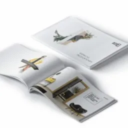 Dwa katalogi produktowe z minimalistycznymi grafikami i układami wnętrz, leżące na białym tle. Otwarty katalog prezentuje czarne krzesło i nowoczesny stolik kawowy, drugi katalog jest zamknięty...