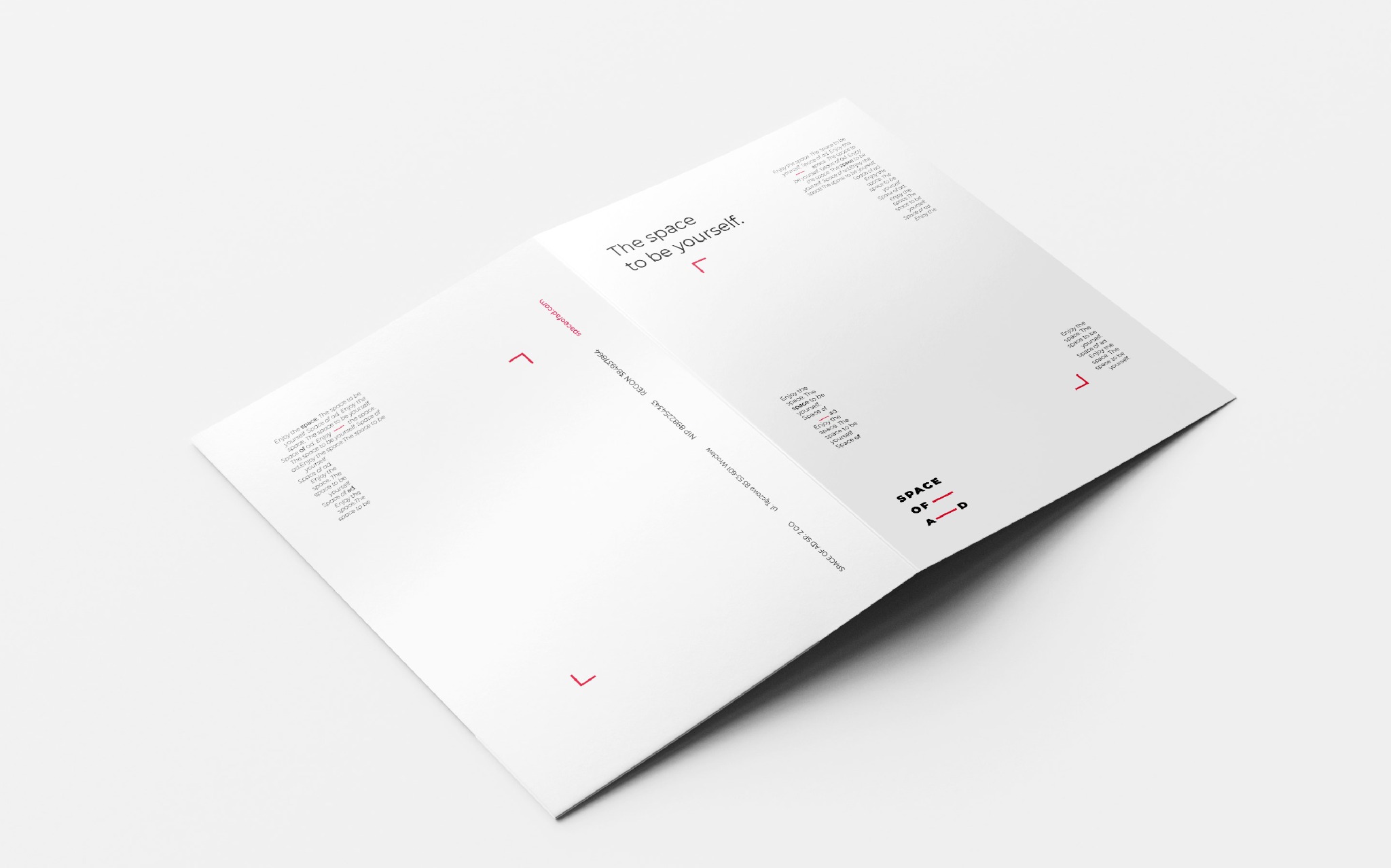 Rozłożona, biała broszura reklamowa z minimalistycznym designem, prezentująca hasło 'The space to be yourself' oraz dane kontaktowe firmy Space of Ad, leżąca na białym tle.