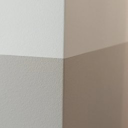 Mar-Gips - Ściana pomalowana na dwa kolory, biały i beżowy, z widocznym narożnikiem w mieszkaniu w Warszawie.