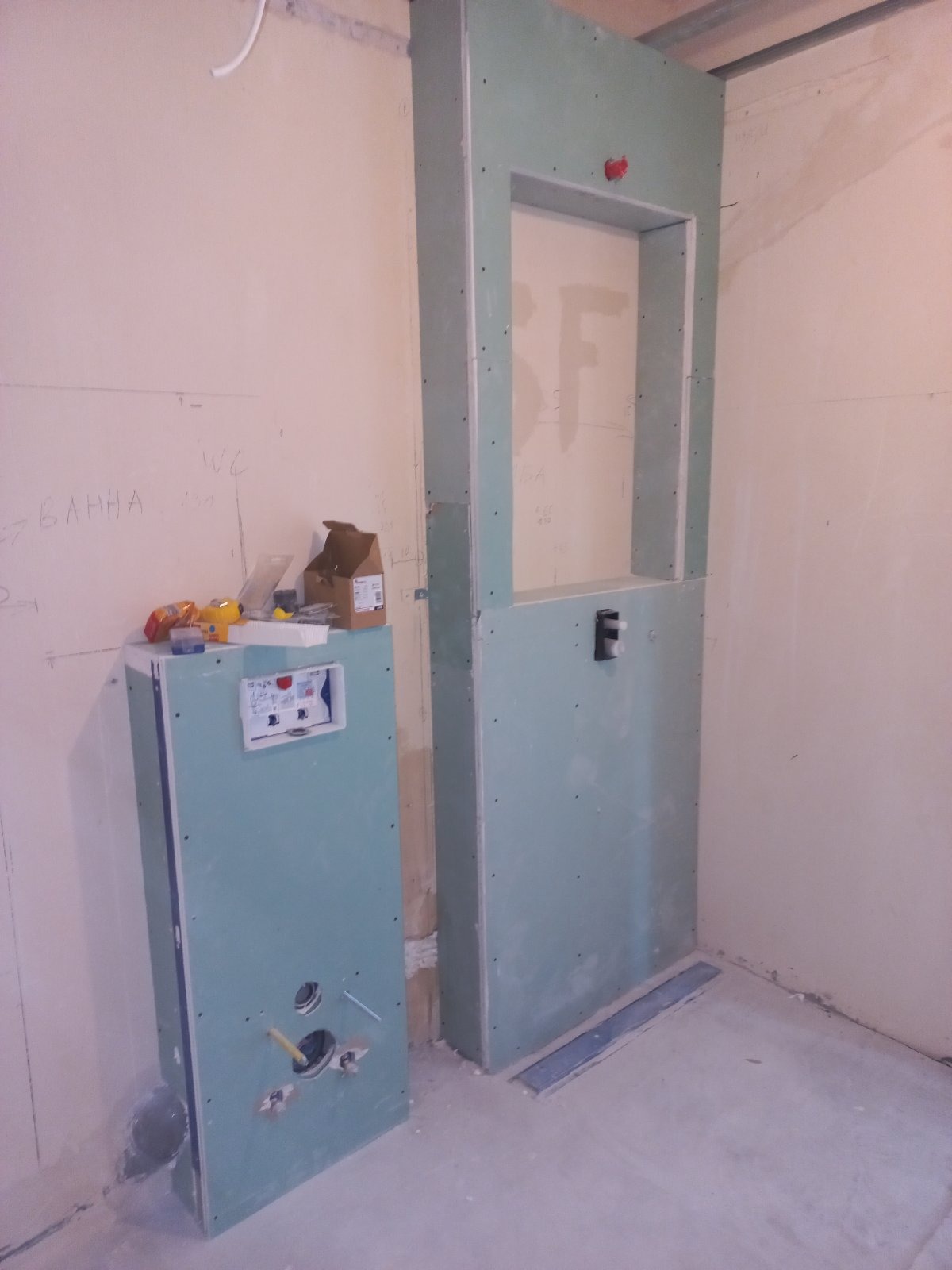 Szkielet zabudowy WC z płyt kartonowo-gipsowych w trakcie prac w Warszawie, widoczne profile, otwory na instalacje, skrzynka elektryczna i narzędzia na obudowie stelaża.