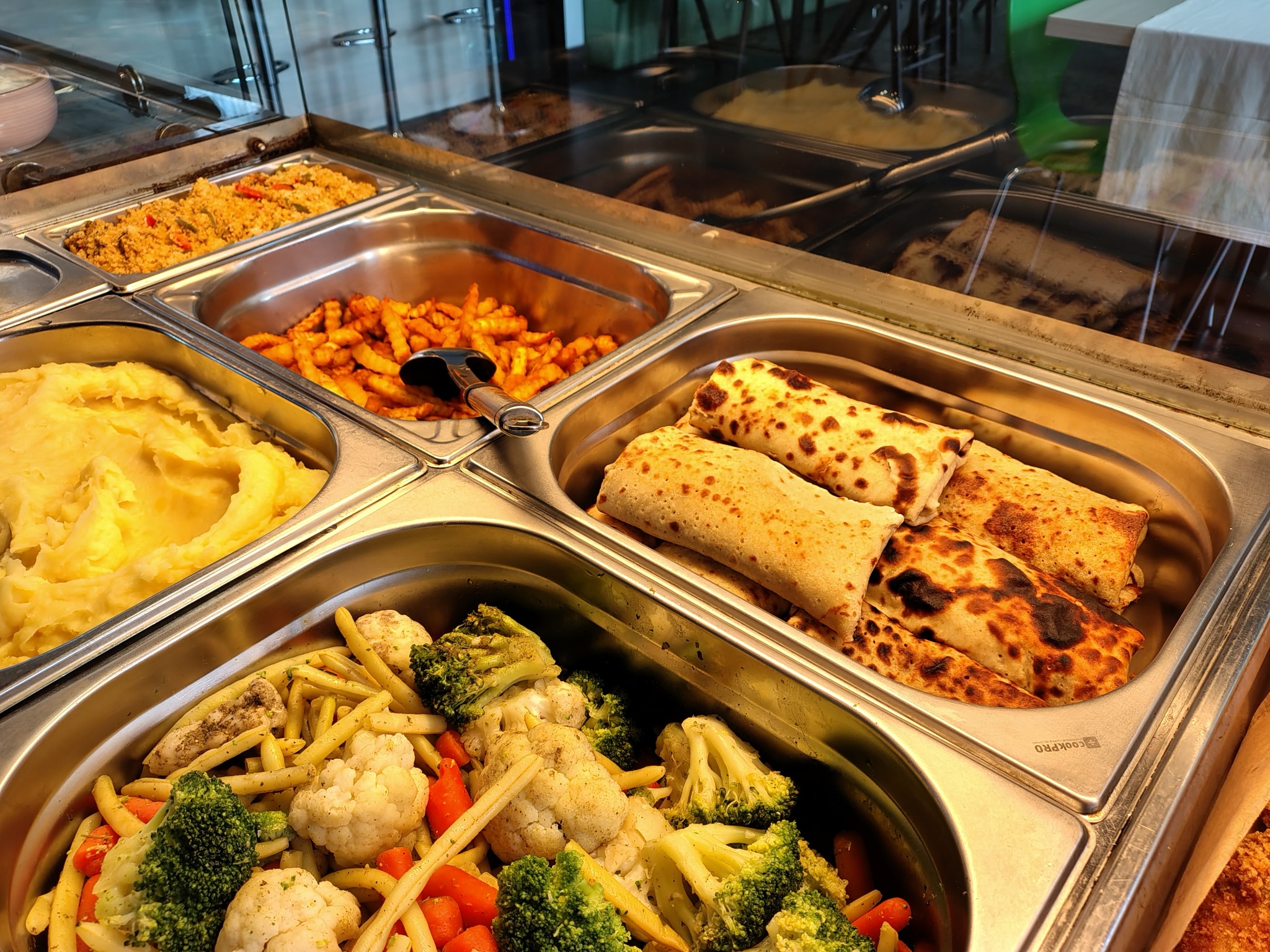 Bufet z różnorodnymi daniami gotowymi w Warszawie: puree ziemniaczane, warzywa gotowane na parze (brokuły, kalafior, marchewka, fasolka), smażone ziemniaki, krokiety i danie ryżowe.