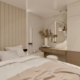 Design Atelier - Nowoczesna sypialnia w beżowych tonacjach z tapicerowanym panelem ściennym, okrągłym lustrem nad toaletką i minimalistycznym oświetleniem punktowym.