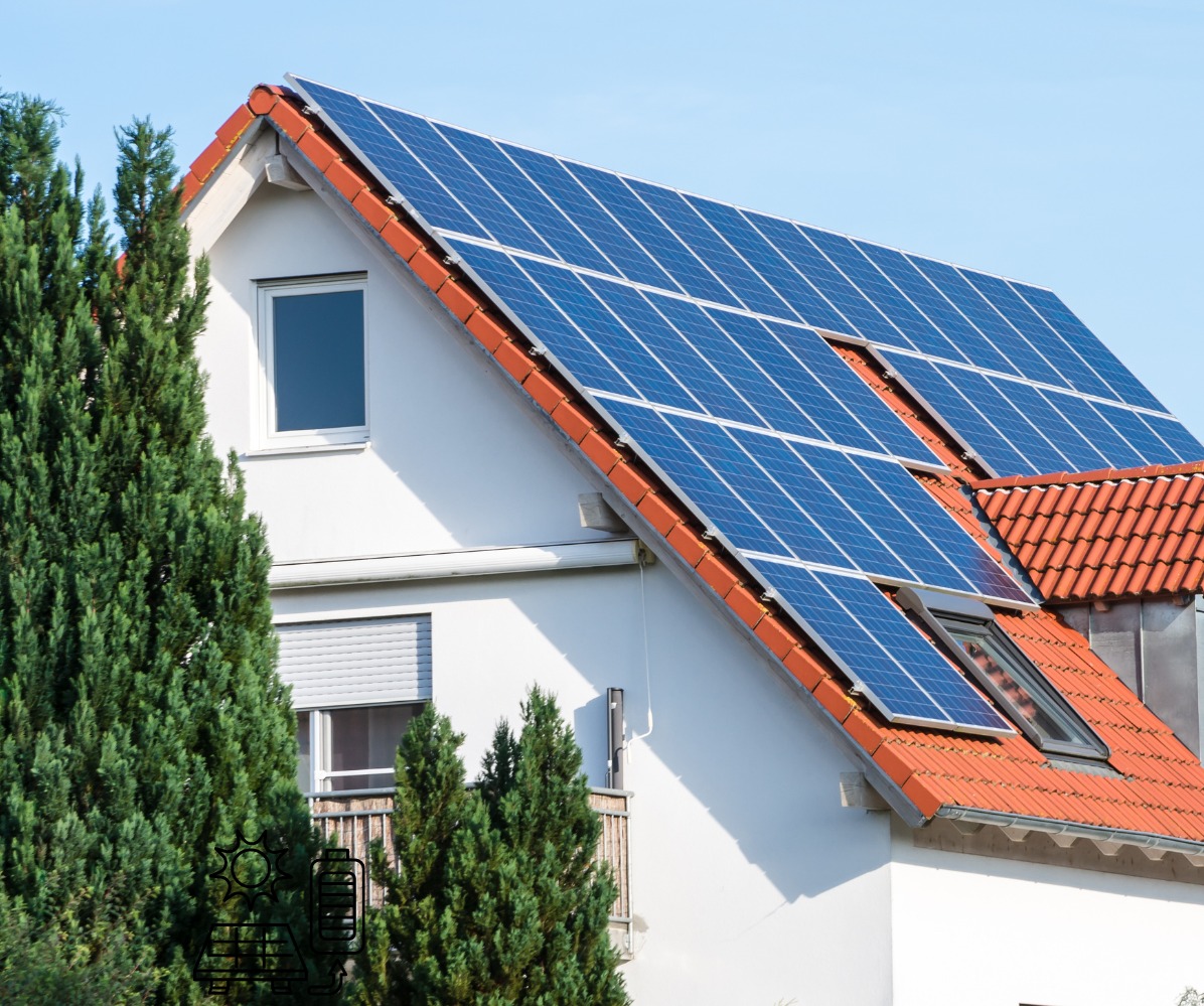 Instalacja fotowoltaiczna na dachu domu jednorodzinnego w Kielcach, widoczna zza wysokich, zielonych drzew iglastych. Panele słoneczne zamontowane na pomarańczowej dachówce. Widoczne okno dachowe.