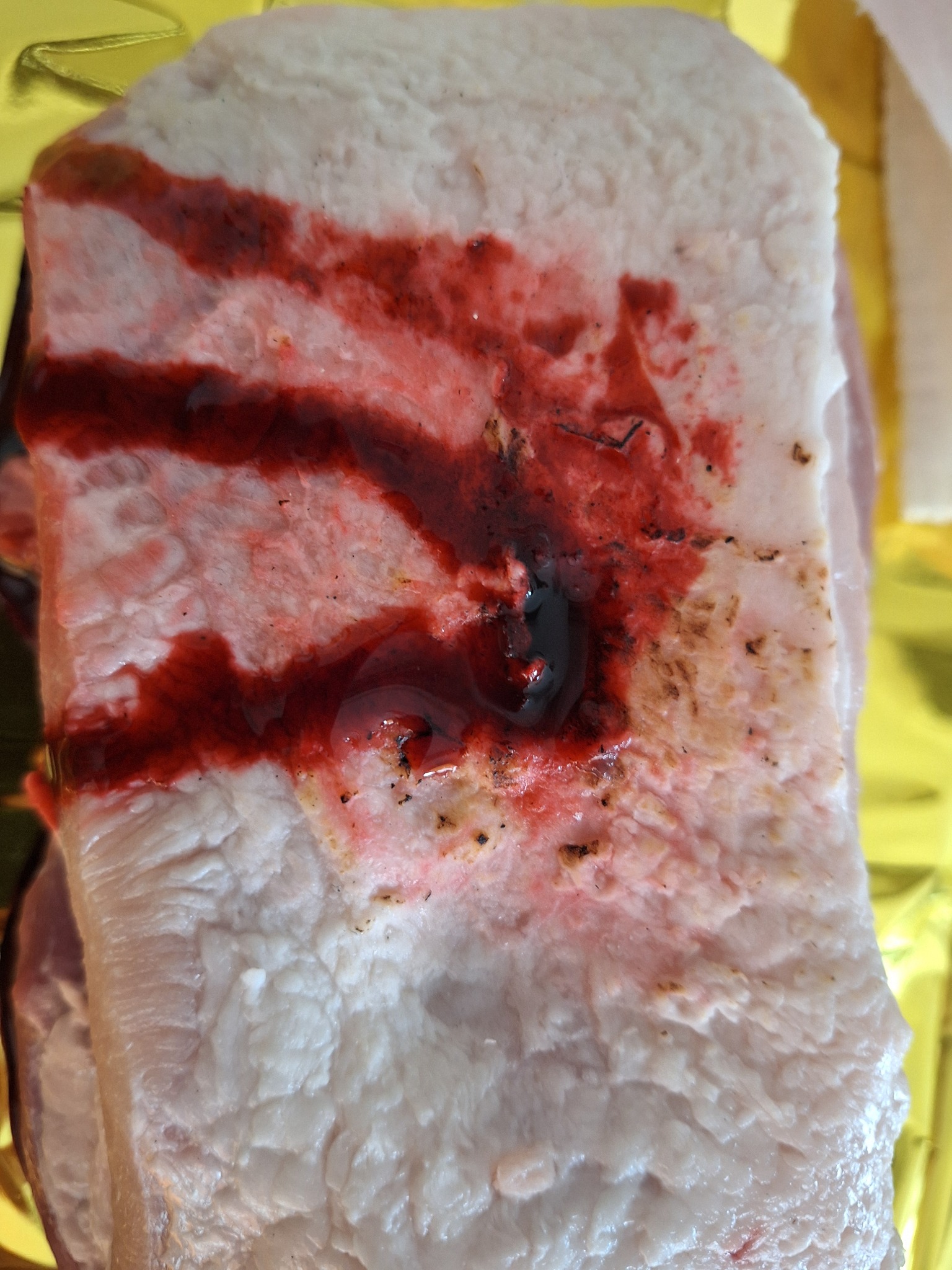 Symulacja rany z krwią na manekinie do ćwiczeń pierwszej pomocy, widoczne ślady po naklejeniu i odklejeniu materiału.