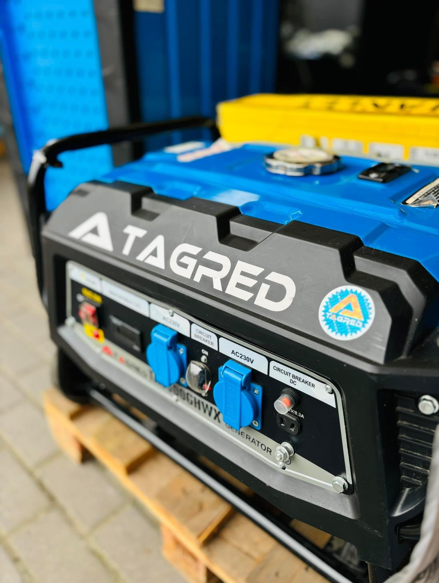 Agregat prądotwórczy marki Tagred na drewnianej palecie, widoczne gniazda AC230V i DC, oraz naklejka z logo firmy.