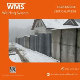 WMS Group Poland Sp. z o.o. - Nowoczesne ogrodzenie z betonowymi słupkami i pionowymi panelami w kolorze grafitowym, widoczne w zimowej scenerii z ośnieżonym domem w tle.