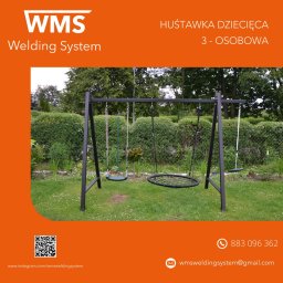 WMS Group Poland Sp. z o.o. - Trzyosobowa huśtawka dziecięca z metalową konstrukcją, okrągłym siedziskiem z siatki i dwoma pojedynczymi siedziskami na tle zielonego ogrodu.