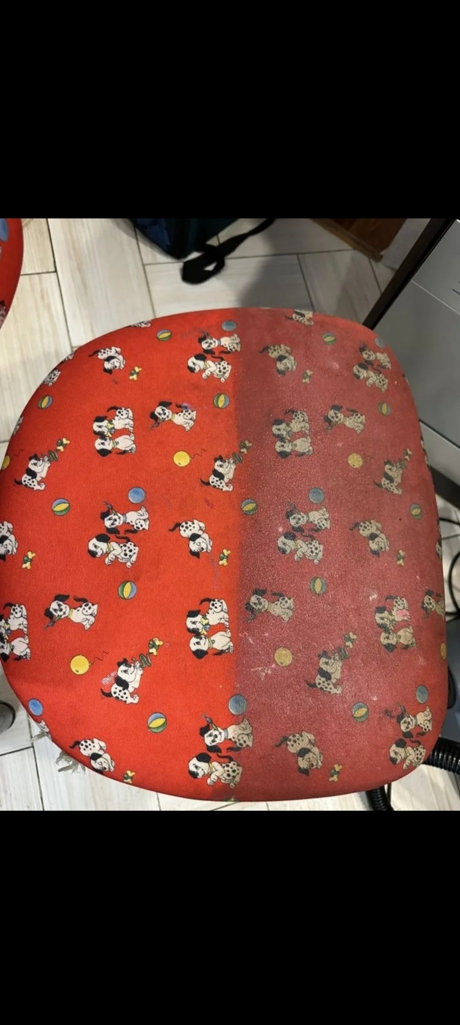 Krzesło biurowe z czerwonym obiciem w dalmatyńczyki, widoczna różnica w czystości po lewej i prawej stronie siedziska.