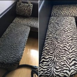 CLEAN MOOD - Fragment sofy z tapicerką w zebrę, widoczne czyszczenie tapicerki za pomocą węża odkurzacza ekstrakcyjnego, podłoga częściowo mokra.