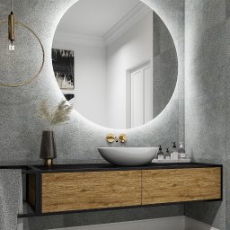 EasyLivin DESIGN - Nowoczesna łazienka z okrągłym lustrem podświetlanym LED, umywalką nablatową i szafką z drewnianymi frontami na tle szarych płytek imitujących beton.