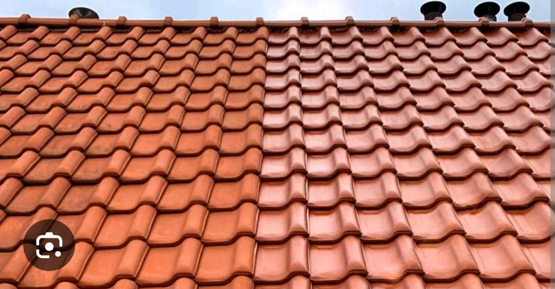 Częściowo wyczyszczony dach z czerwonej dachówki ceramicznej, widoczne kominki wentylacyjne na szczycie.