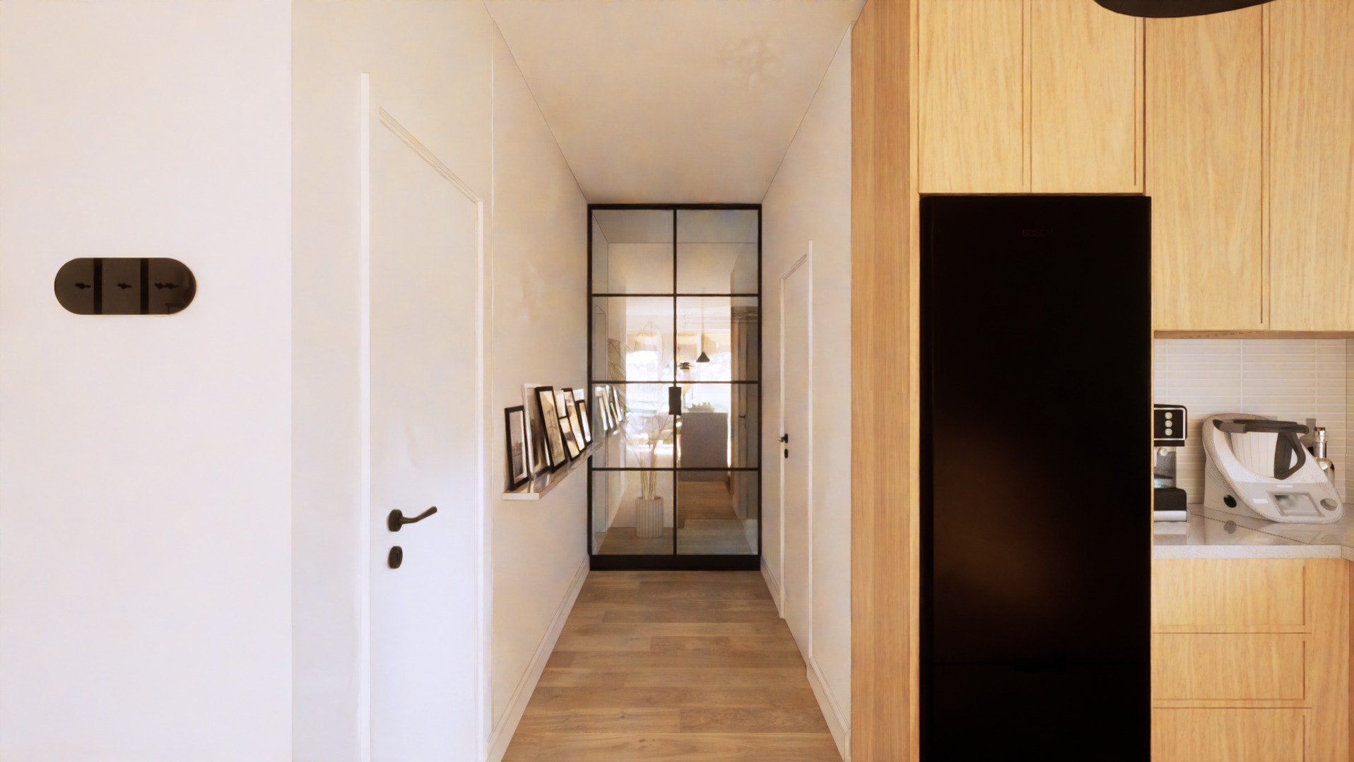 Wąski korytarz z drewnianą podłogą, białymi ścianami i czarnymi akcentami, w tym szklanymi drzwiami z metalową ramą, wieszakiem na klucze i ramkami zdjęć na półce.