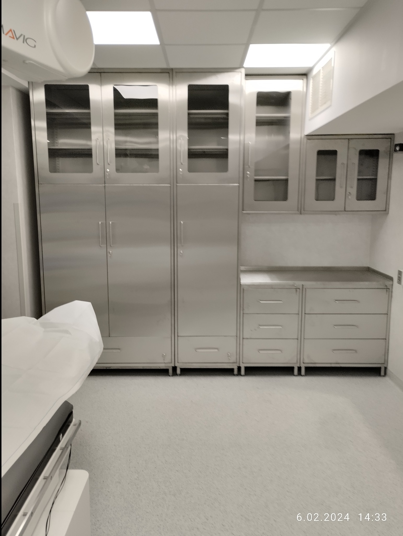 Wyposażenie medyczne ze stali nierdzewnej w Płośnicy: szafy z przeszkleniami i szafki z szufladami w sterylnym pomieszczeniu.