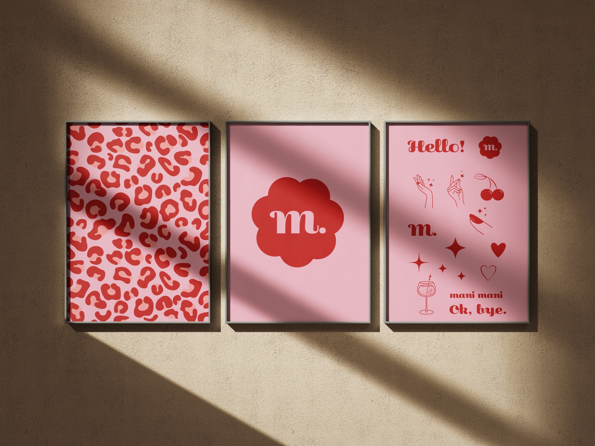 Trzy plakaty w cienkich, czarnych ramkach wiszą na beżowej ścianie oświetlonej smugą światła. Plakaty mają różowe tło i czerwone grafiki: panterkowy wzór, stylizowany obłoczek z literą 'm'...