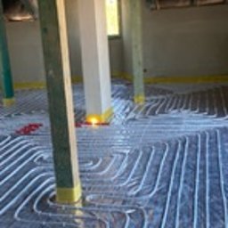 HydroMax - Montaż rur ogrzewania podłogowego na folii izolacyjnej w surowym wnętrzu poddasza z drewnianą konstrukcją stropu.