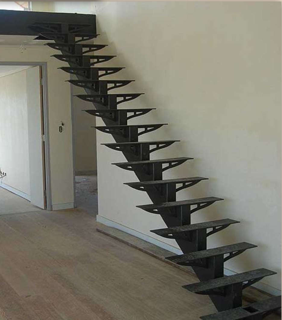 Nowoczesne schody metalowe bez balustrady, z ażurową konstrukcją wspornikową, w jasnym wnętrzu z drewnianą podłogą i białymi ścianami. Minimalistyczny design.